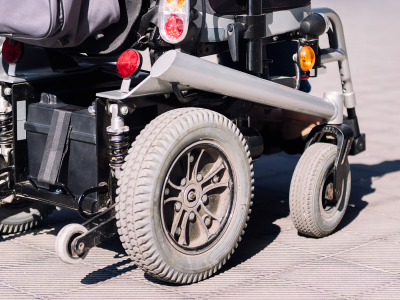 Wheels of an electric wheelchair on a brick walkway