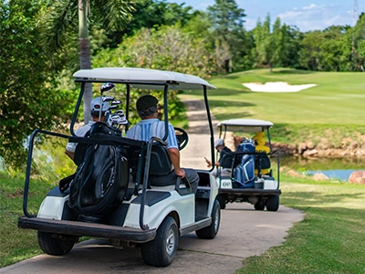 Two golf carts traveling on a path in a golf course