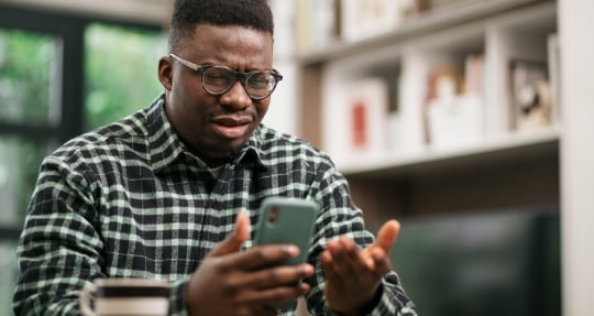Man looking confused holding a phone