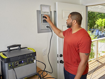 Two guys hooking up a Generator to a circuit box