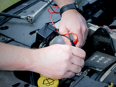Employee using a tester on a battery