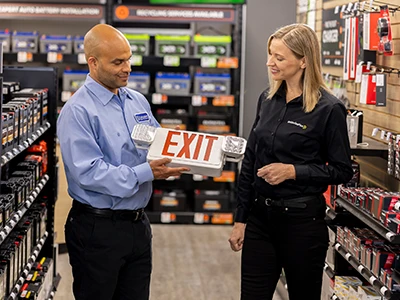 Employee showing a customer an exit sign