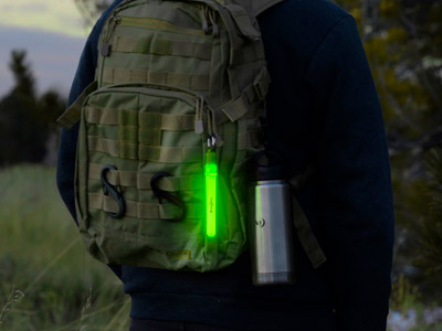 Person wearing a backpack with a water bottle and a glow stick