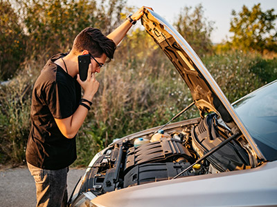 Guy on the phone looking under the hood
