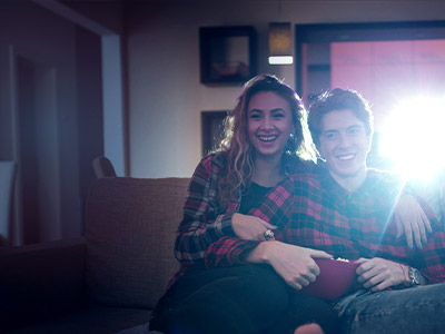 A couple sitting on the couch watching a movie