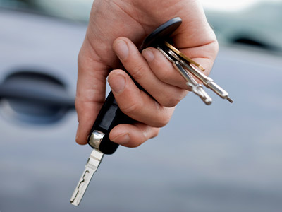 Person holding keys at their side walking to a vehicle