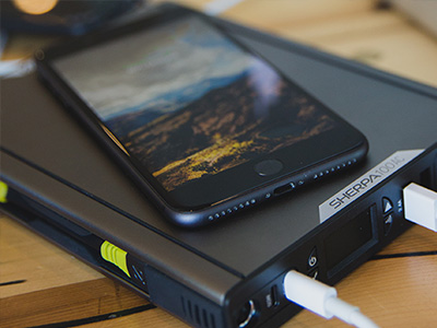 Cell phone sitting on top of a portable Charger